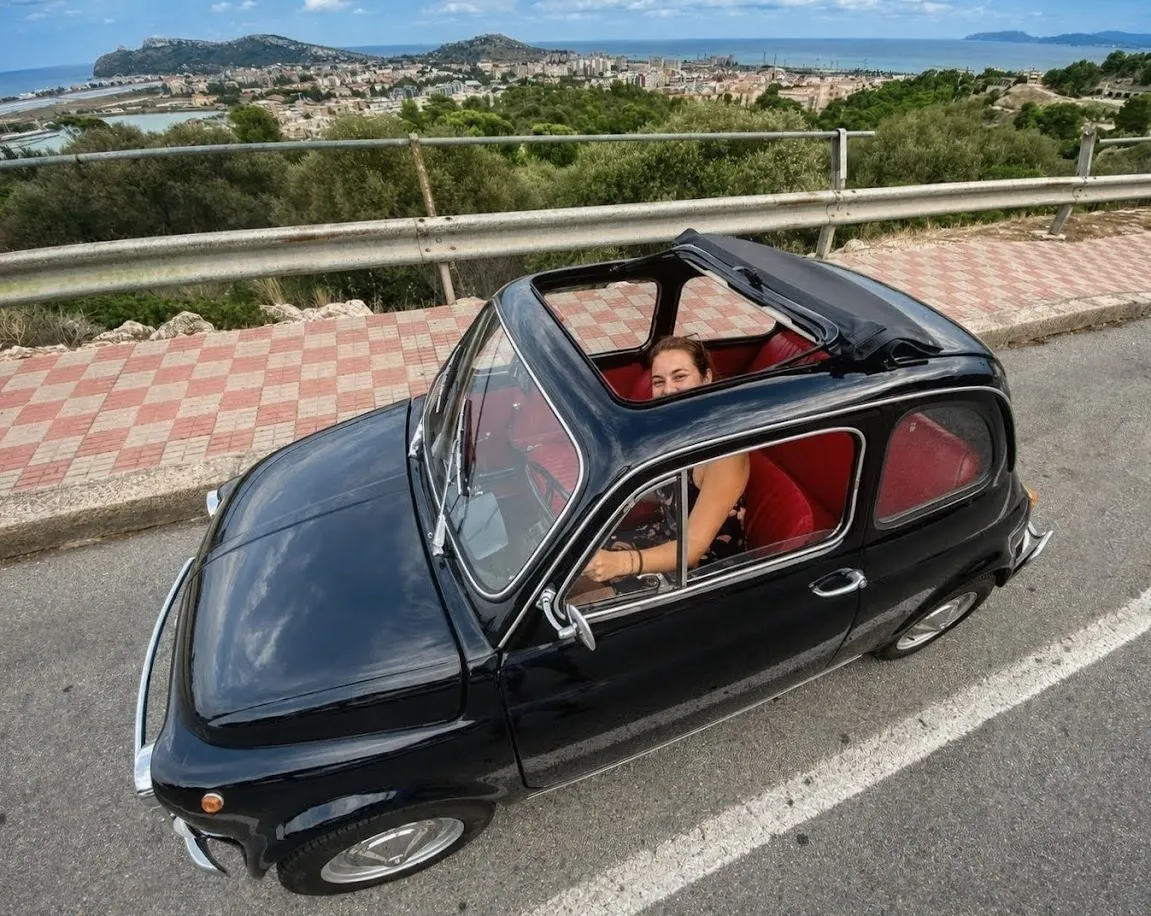 Black Fiat 500 on a panoramic road with a view of Cagliari, rental with driver for weddings and events